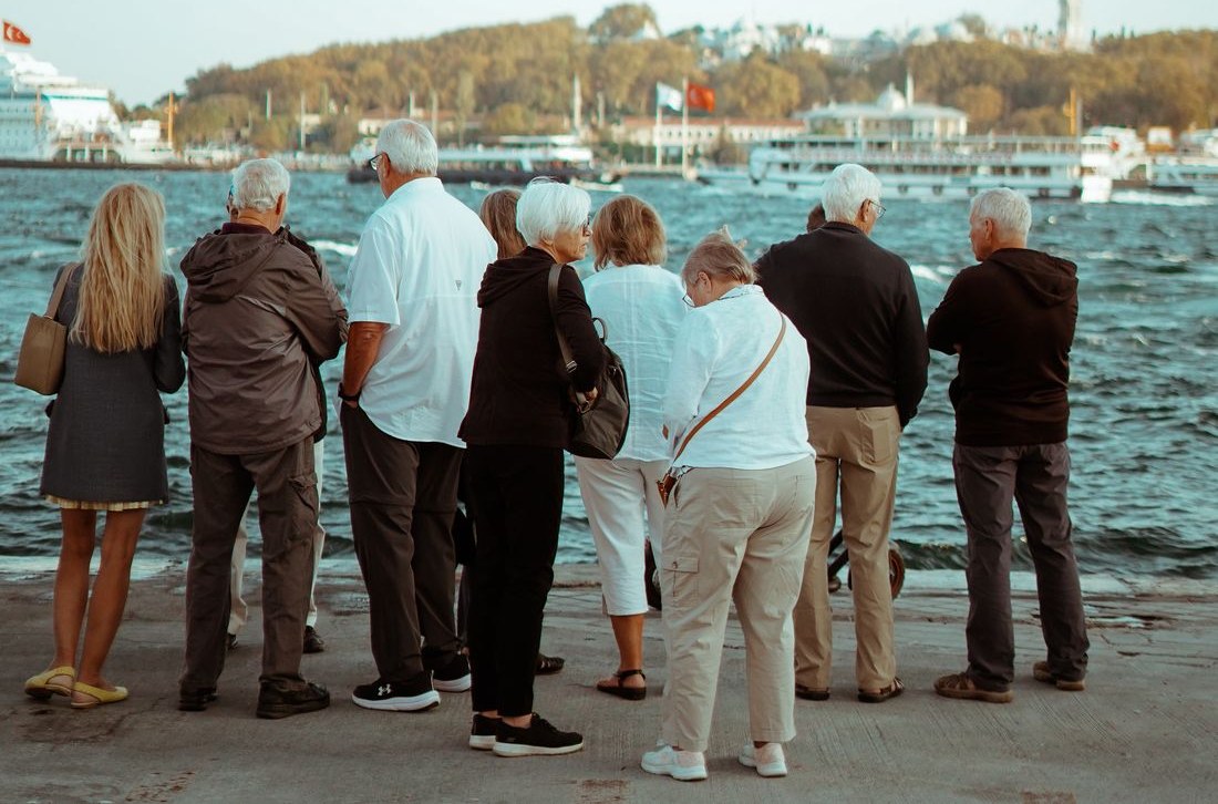 A group of older travellers together on a waterfront outing
